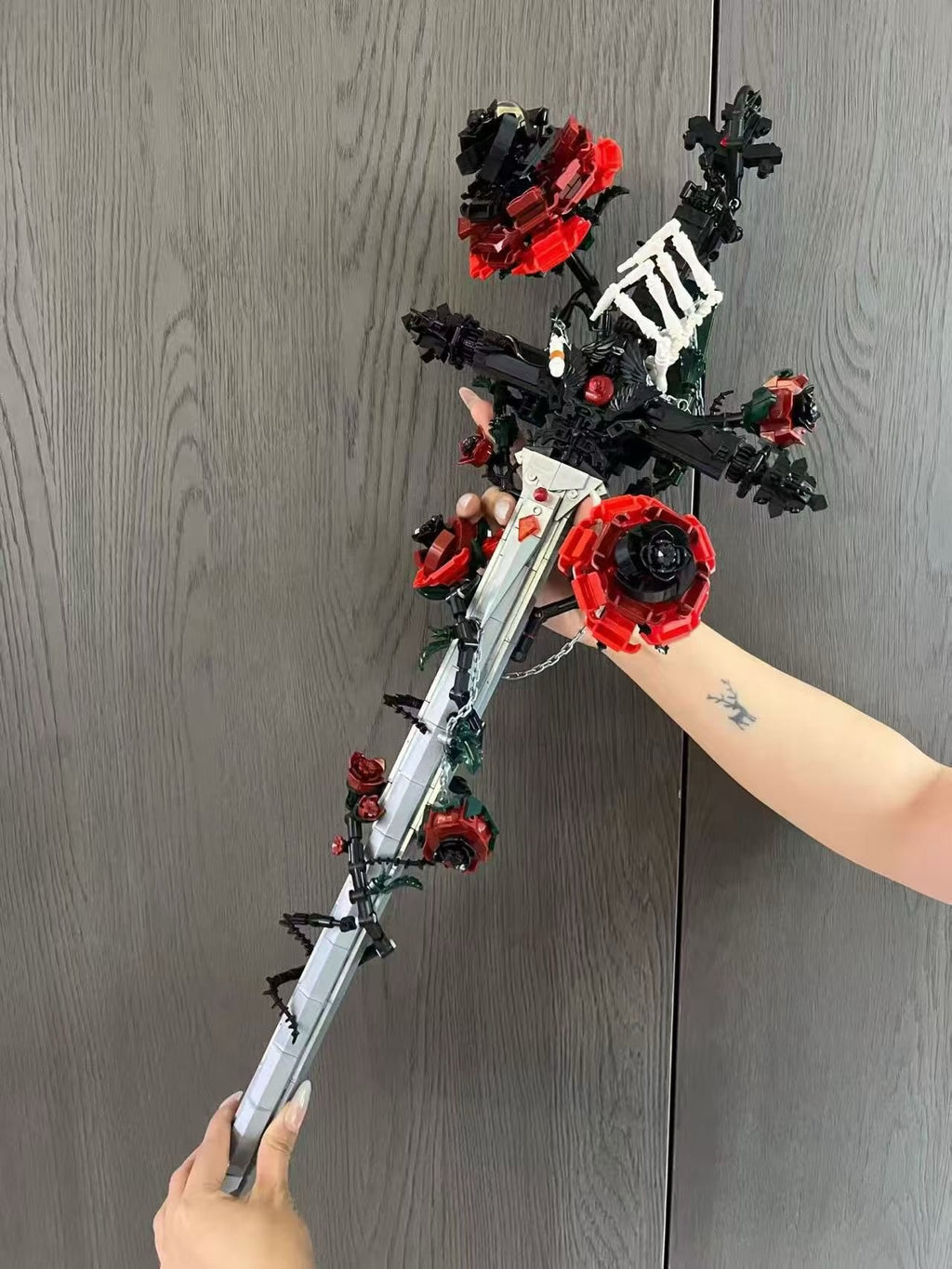 Gothic rose sword building block display featuring black and red floral accents on a decorative base.